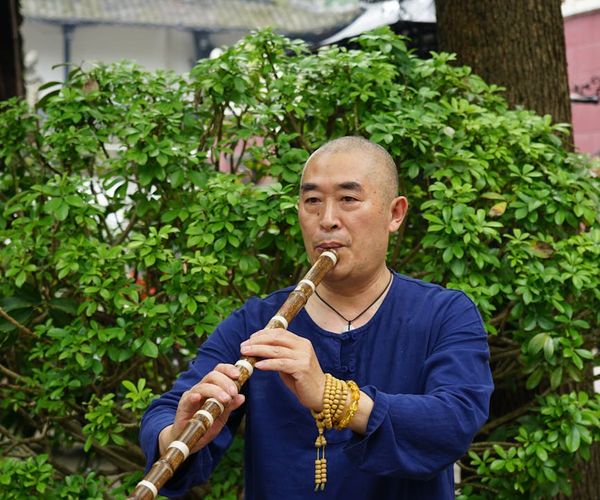 Person meditating outdoors with a calm and focused expression.