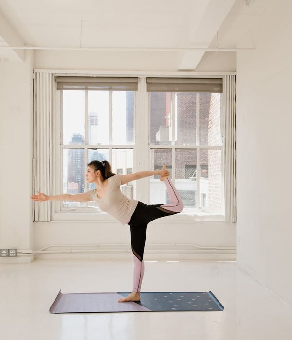 Woman in a peaceful yoga pose in a bright, modern studio.